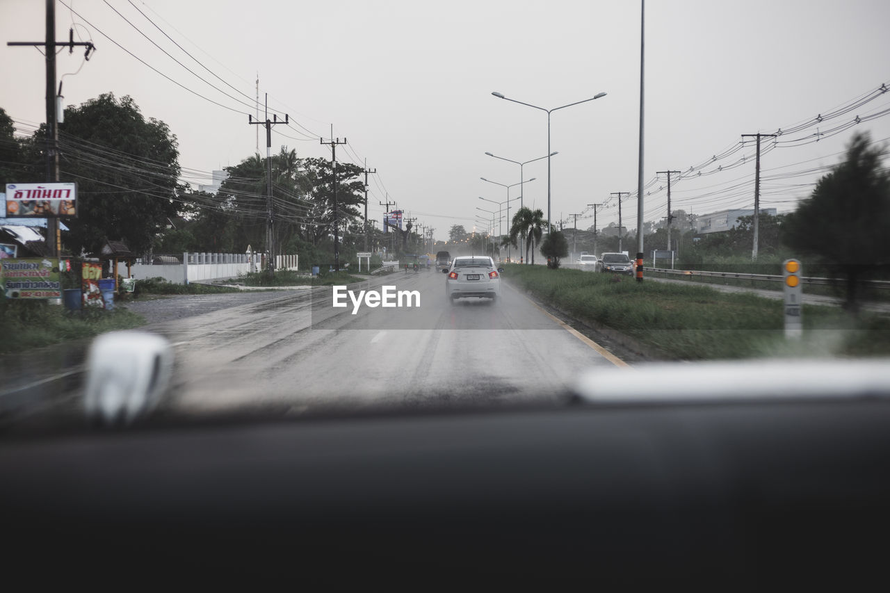 CARS ON STREET IN CITY SEEN THROUGH WINDSHIELD