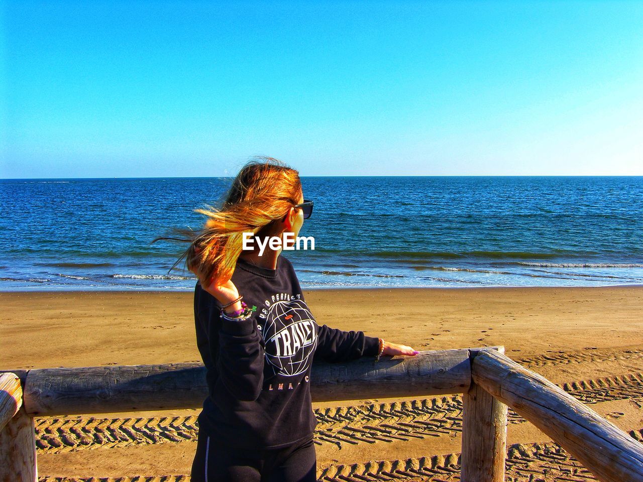 REAR VIEW OF MAN LOOKING AT SEA AGAINST SKY