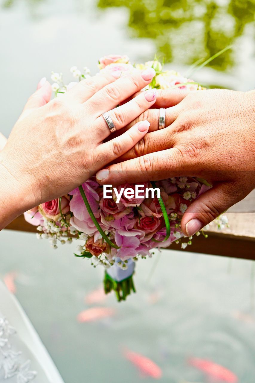 Cropped image of couple holding bouquet