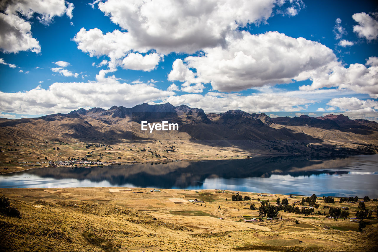 Scenic view of lake by mountains against sky