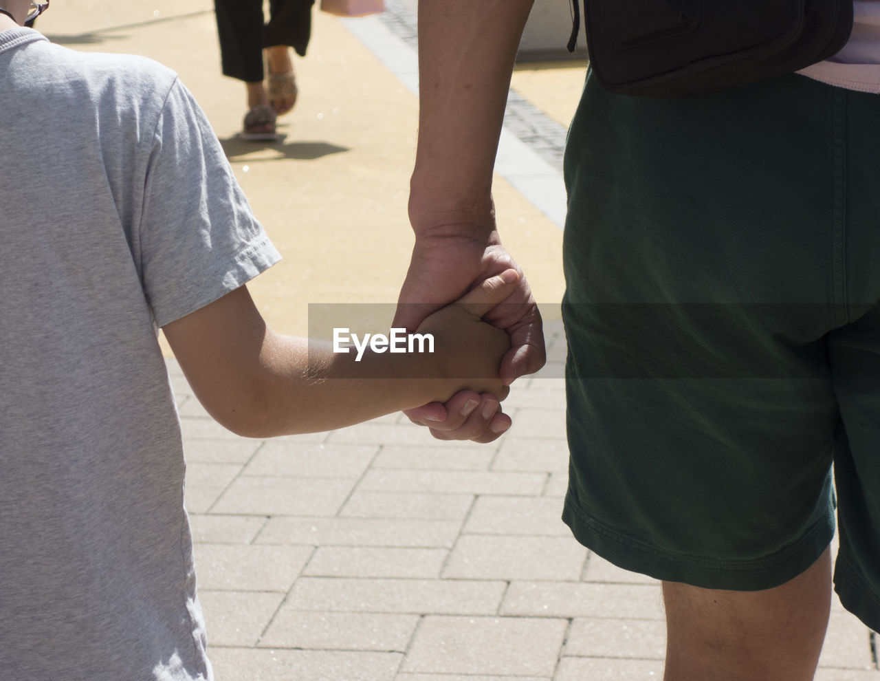 REAR VIEW OF COUPLE HOLDING HANDS