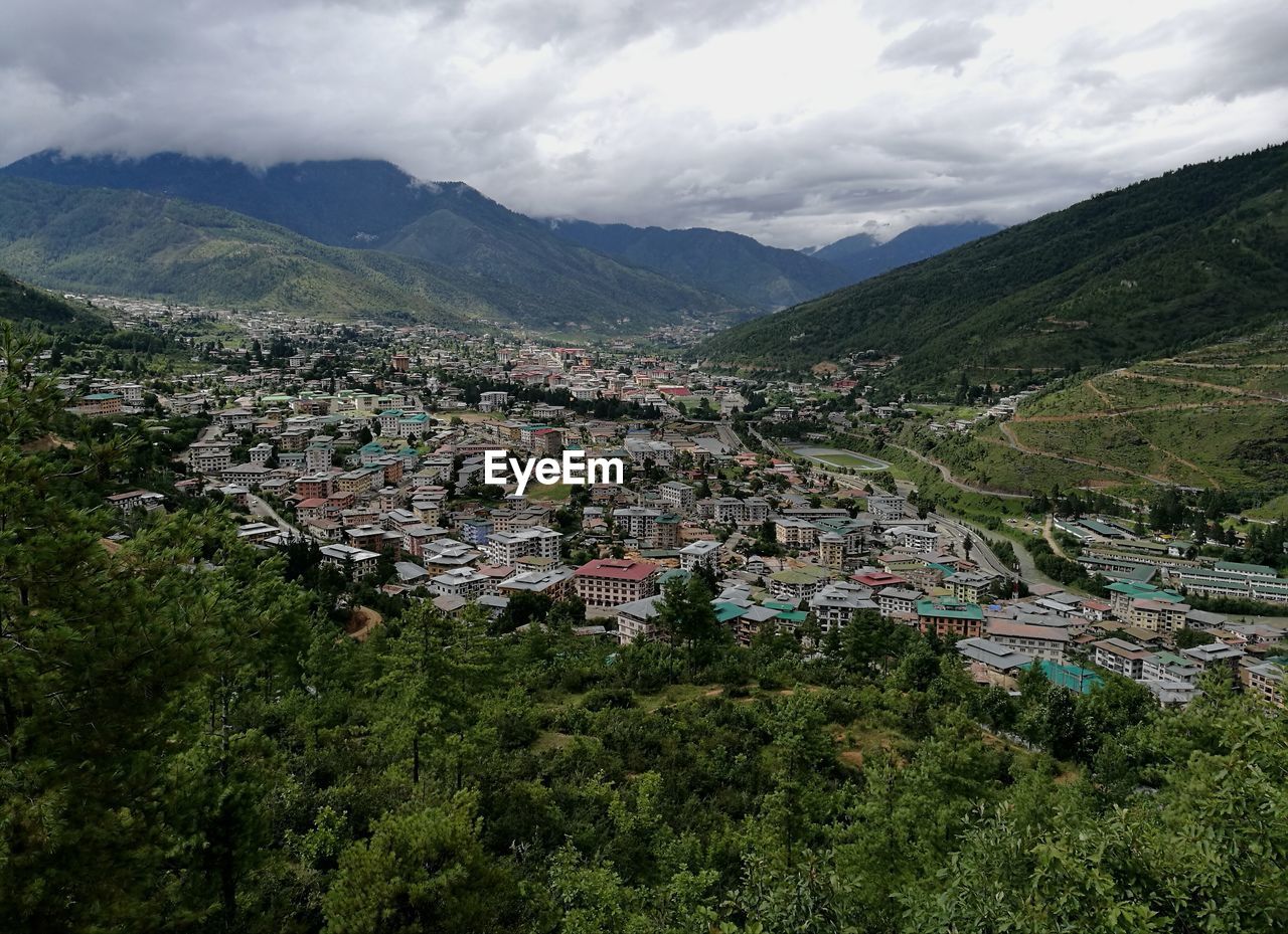 HIGH ANGLE VIEW OF TOWNSCAPE BY MOUNTAIN AGAINST SKY