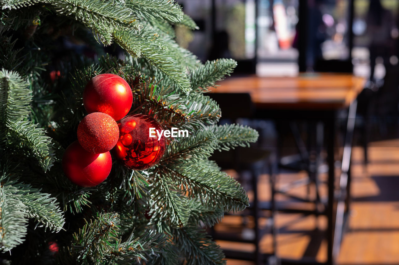 Close up christmas tree with decoration on red and sparkling ball with copy space 