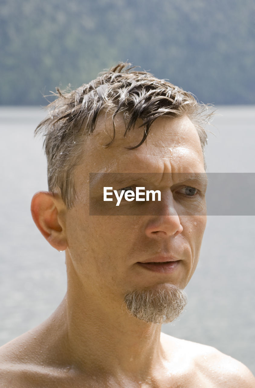 Close-up of shirtless mature man looking away