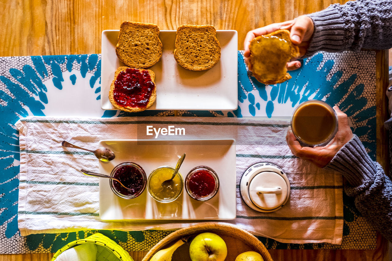 Cropped hands of woman having breakfast at table