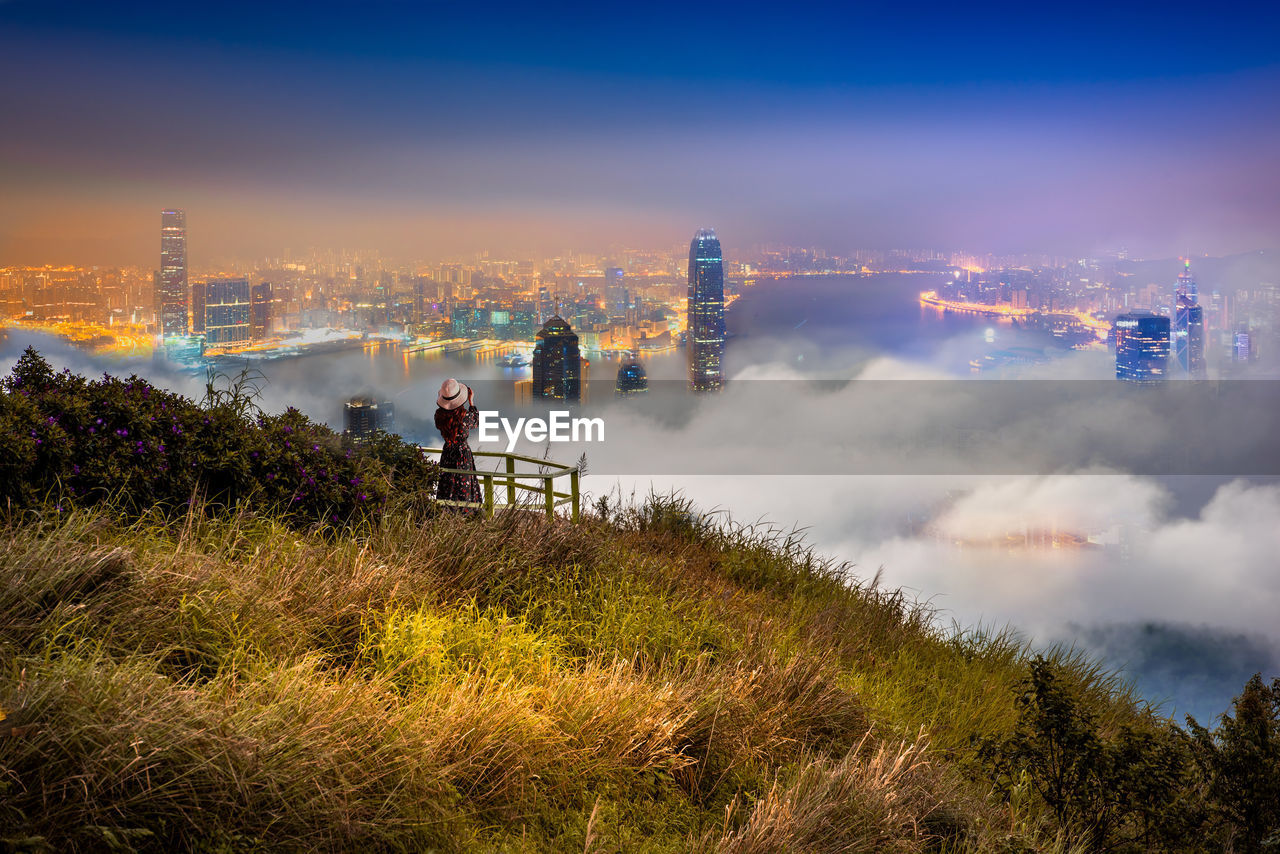 Mountain by illuminated city at night