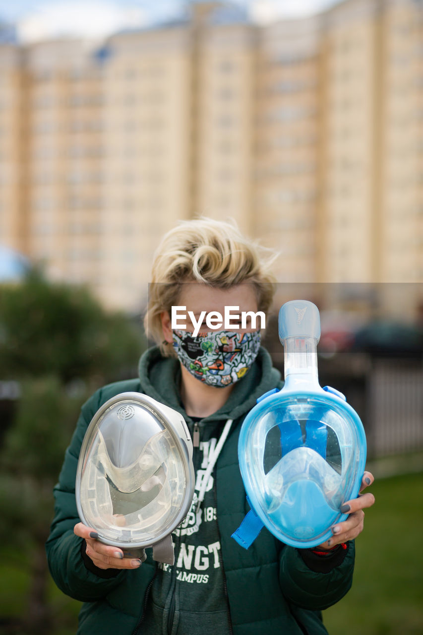 Portrait of woman holding camera in city