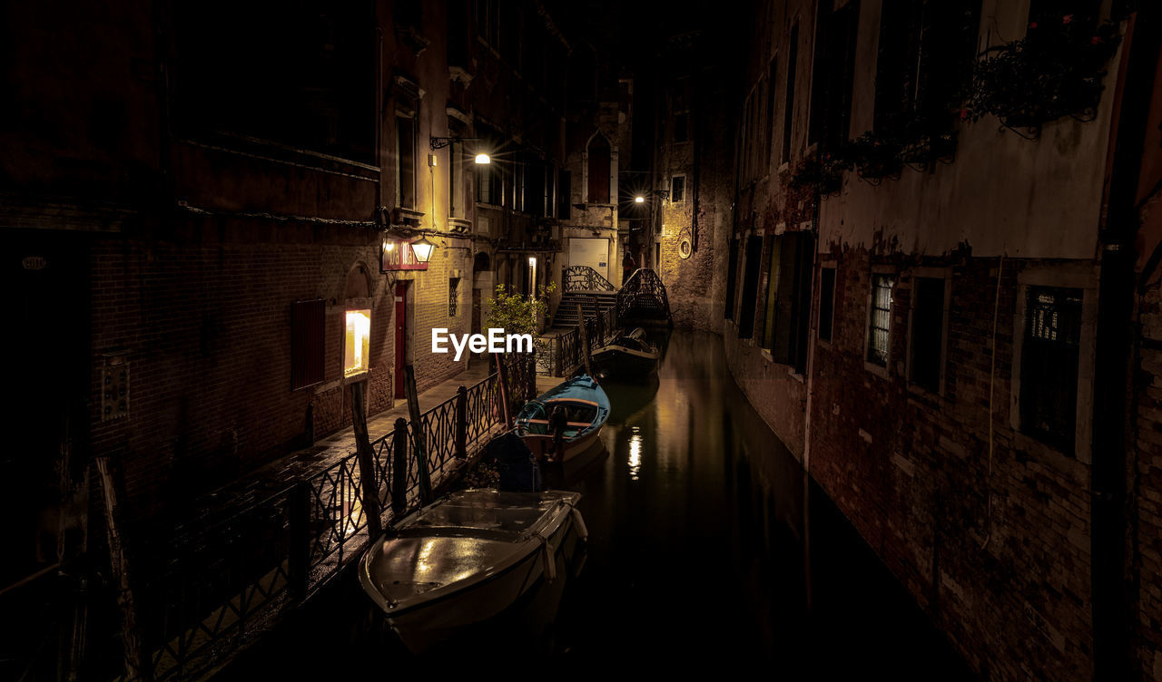 View of canal amidst buildings in city at night