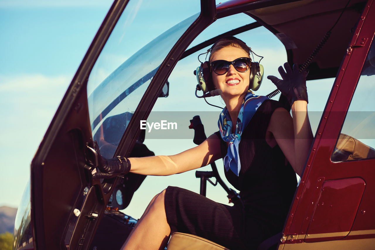 Female pilot sitting in helicopter