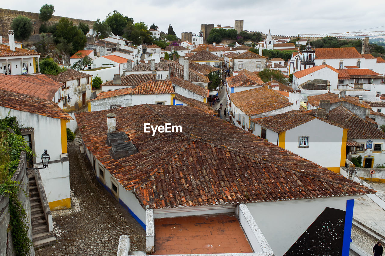 High angle view of houses in medieval town of obidos with castle against sky