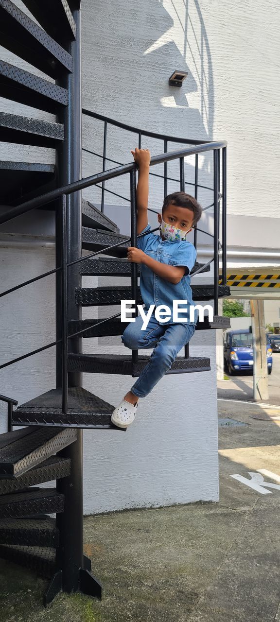 Boy on railing against built structure