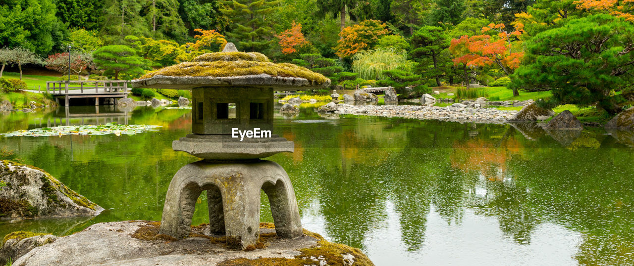 Built structure by lake against trees