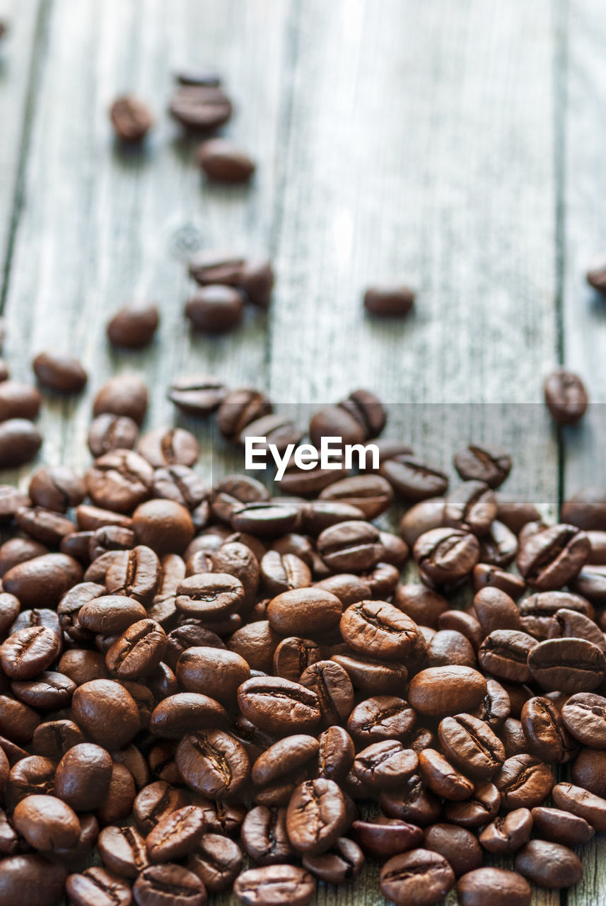 Close-up of coffee beans on aged wooden table