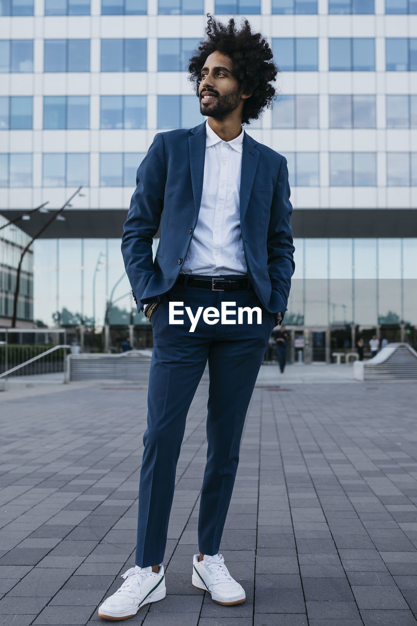 Spain, barcelona, stylish young businessman standing in the city