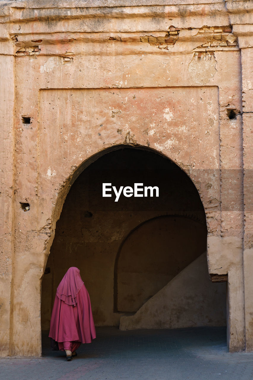 rear view of woman standing in tunnel