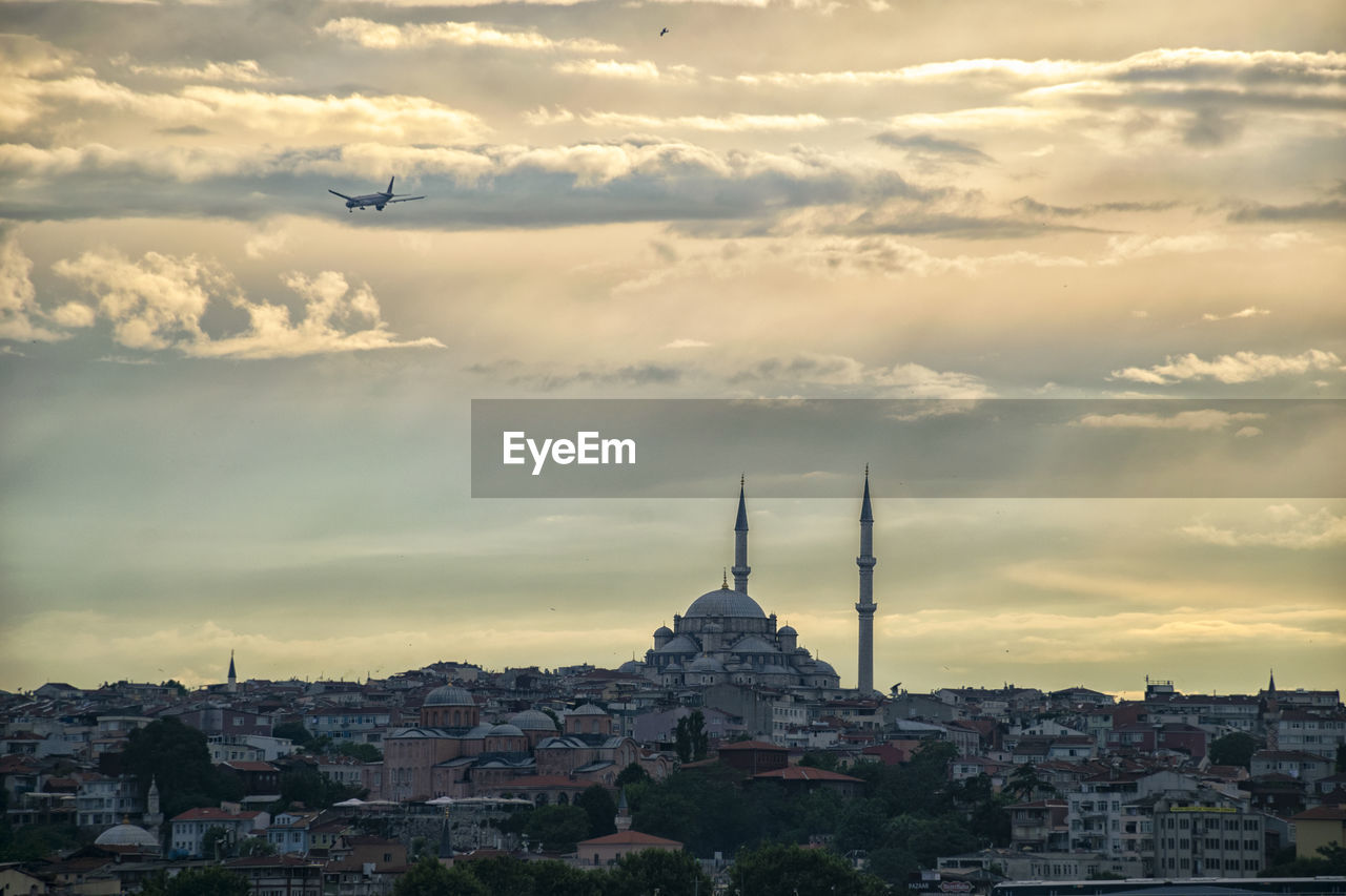 Buildings in city against cloudy sky