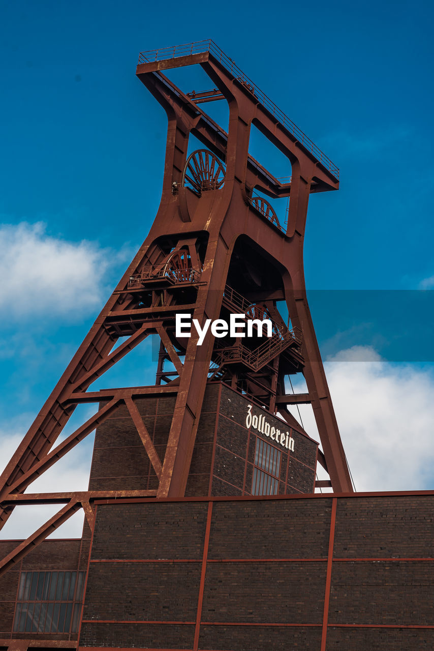 LOW ANGLE VIEW OF OLD MACHINERY AGAINST SKY