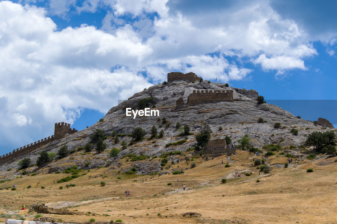 BUILT STRUCTURE ON MOUNTAIN AGAINST SKY