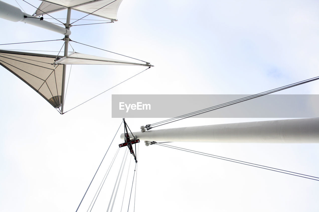 Low angle view of boat masts against sky