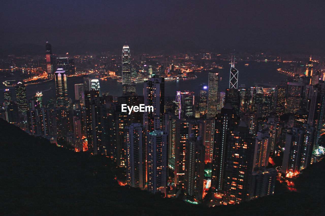 High angle view of illuminated cityscape against sky at night