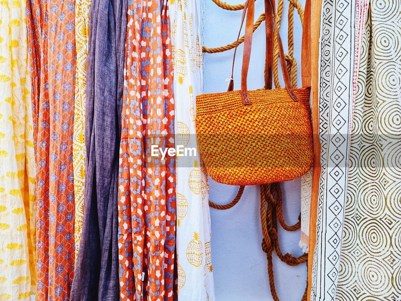 orange, hanging, clothing, pattern, fashion accessory, textile, yellow, multi colored, no people, retail, indoors, fashion, handbag, art, variation, for sale, craft, market, orange color, coathanger, store, dress, shopping, close-up, retail display, still life, bag