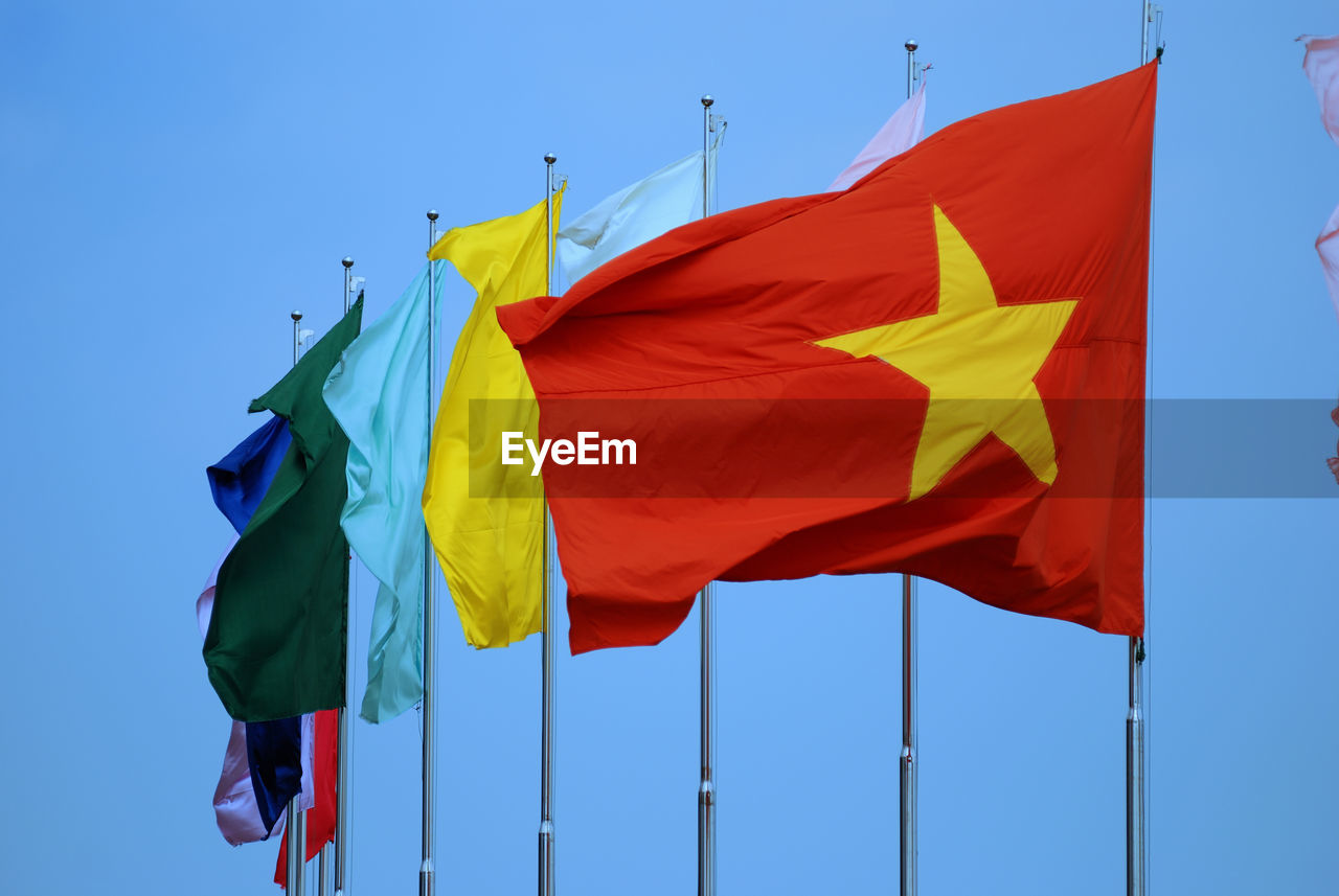 Close-up of flags against clear blue sky