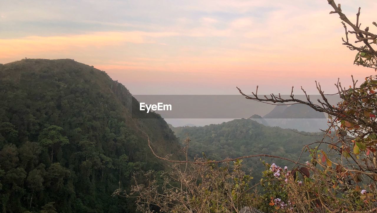SCENIC VIEW OF MOUNTAINS AGAINST ORANGE SKY