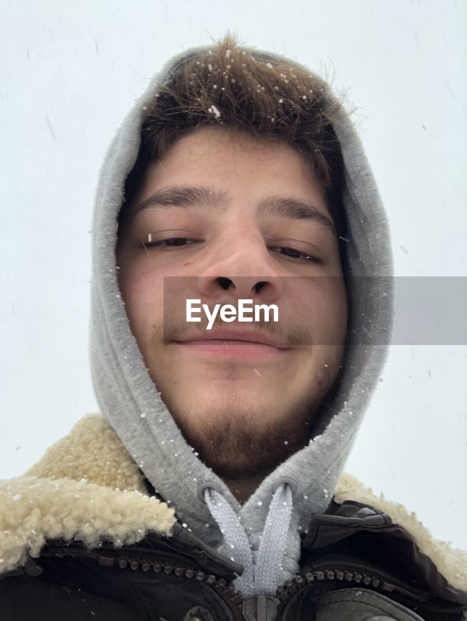 CLOSE-UP PORTRAIT OF SMILING MAN WITH SNOW IN MOUTH