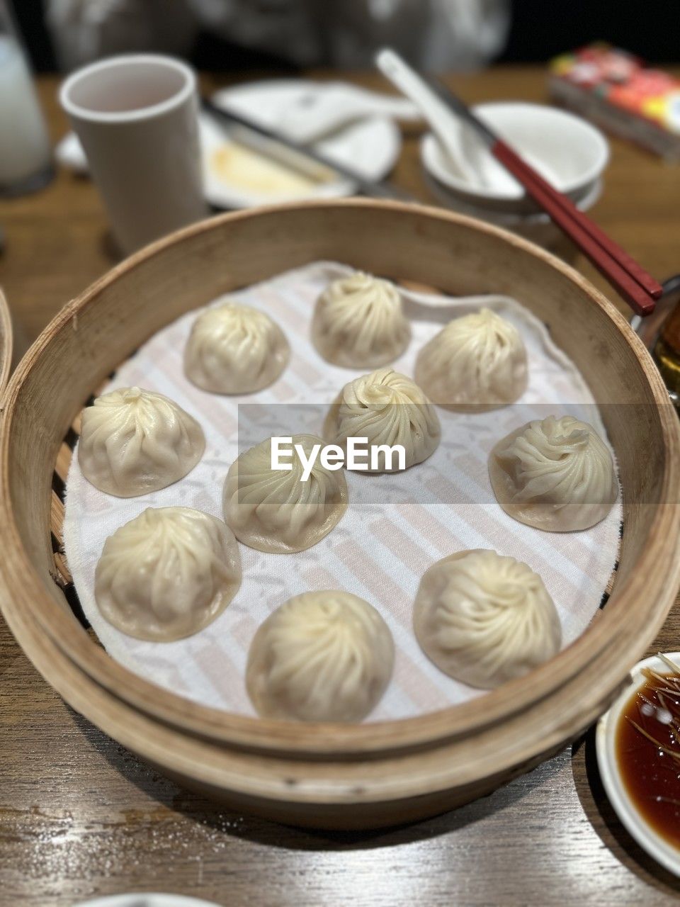 food and drink, food, dish, xiaolongbao, dumpling, khinkali, dim sum, buuz, chinese food, cuisine, freshness, healthy eating, mandu, chinese dumpling, no people, indoors, dessert, asian food, wellbeing, manti, table, steamed, high angle view, still life, siopao, meal