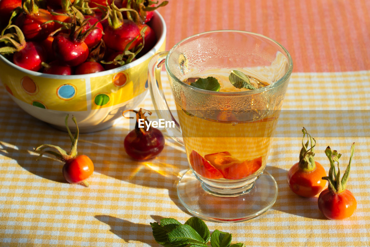 Rose hip tea and wild rose fruits in a bowl. close-up.