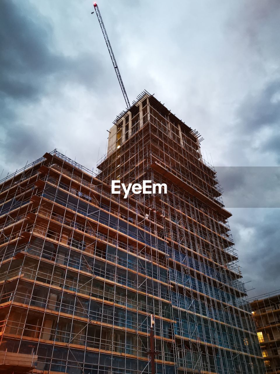 LOW ANGLE VIEW OF BUILDINGS AGAINST CLOUDY SKY