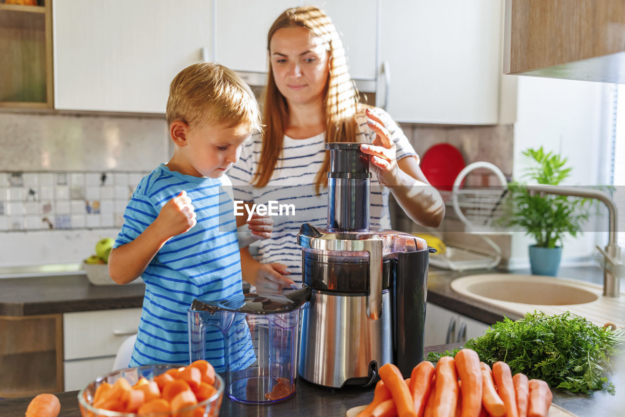 portrait of smiling boy standing in kitchen