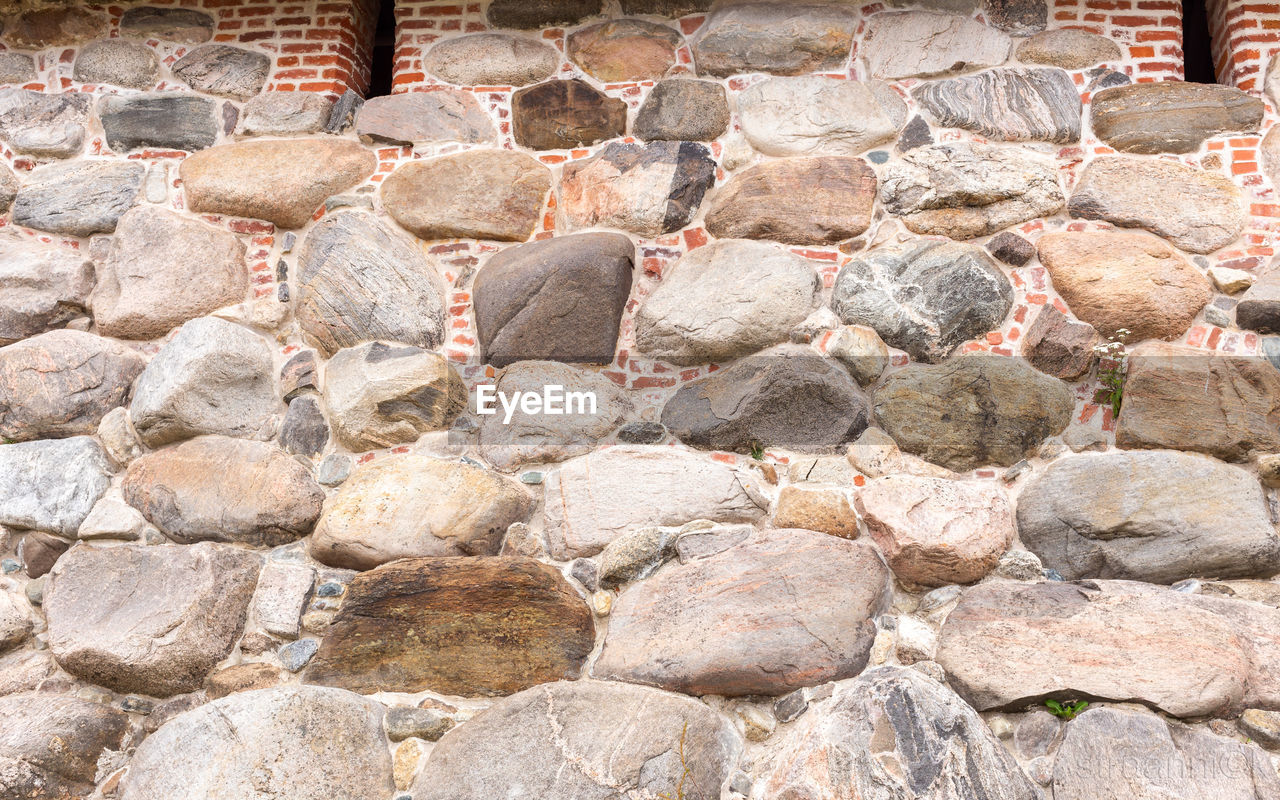 FULL FRAME SHOT OF STONE WALL WITH ROCKS