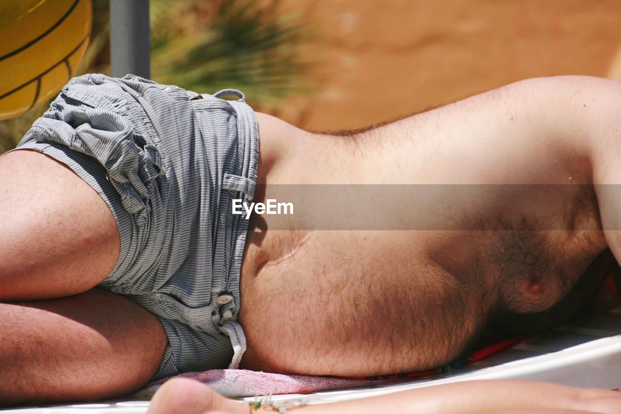 CLOSE-UP OF MAN LYING DOWN ON FLOOR