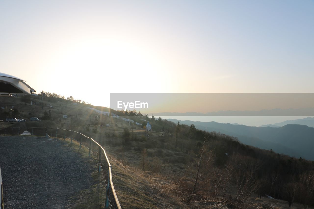 ROAD BY MOUNTAINS AGAINST CLEAR SKY