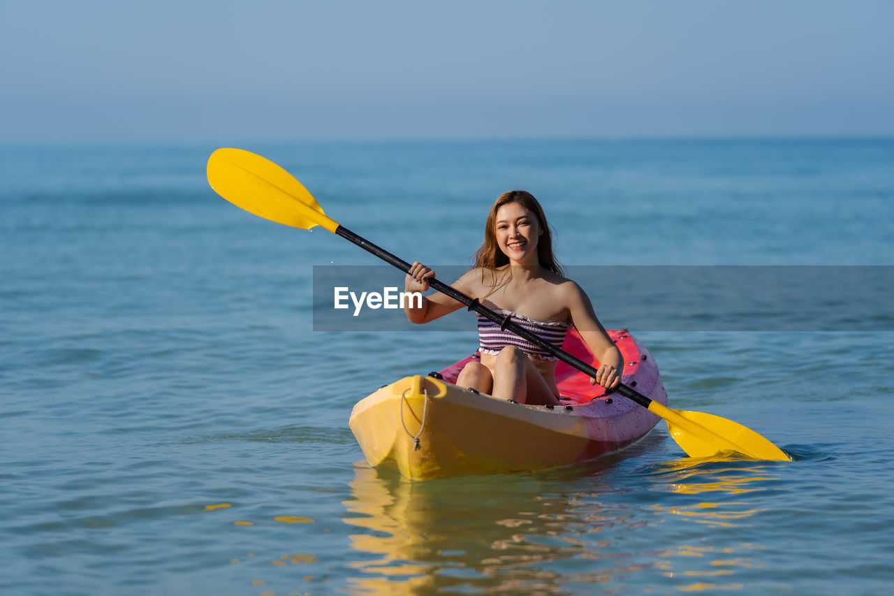 portrait of young man kayaking in sea