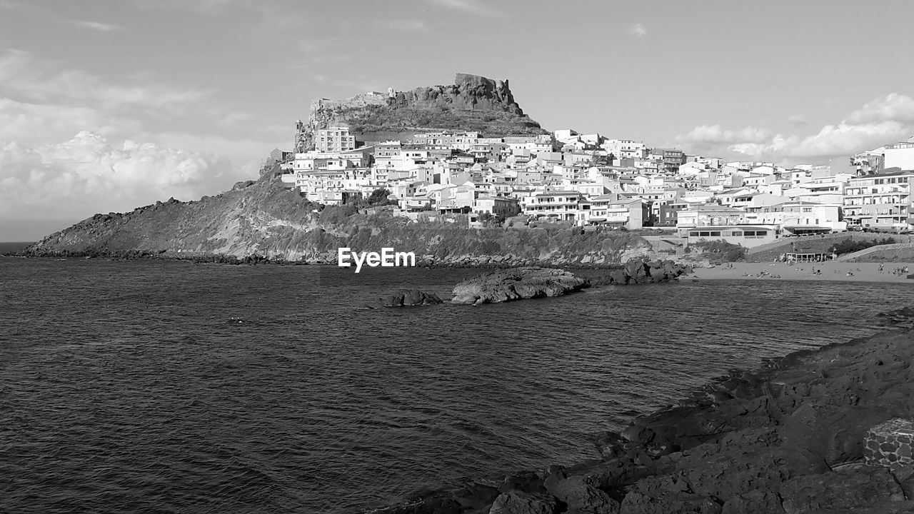 BUILDINGS BY SEA AGAINST SKY