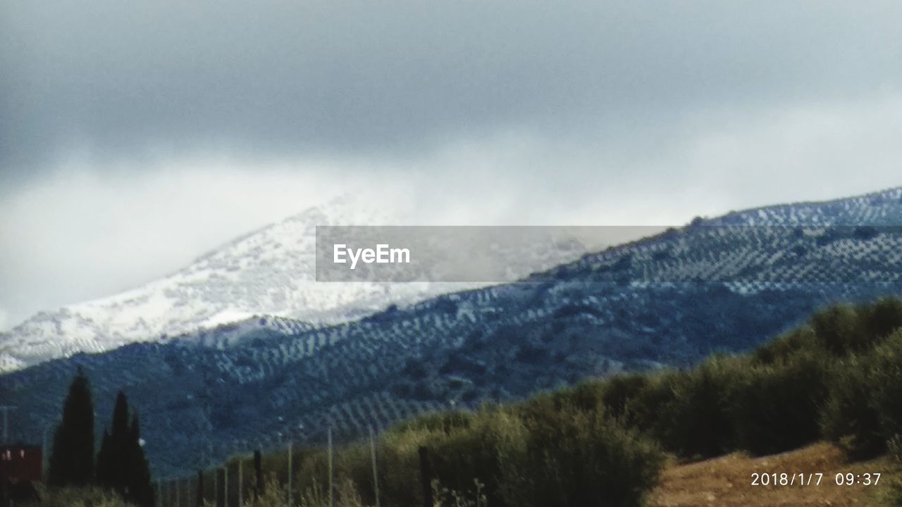 CLOSE-UP OF MOUNTAINS AGAINST SKY