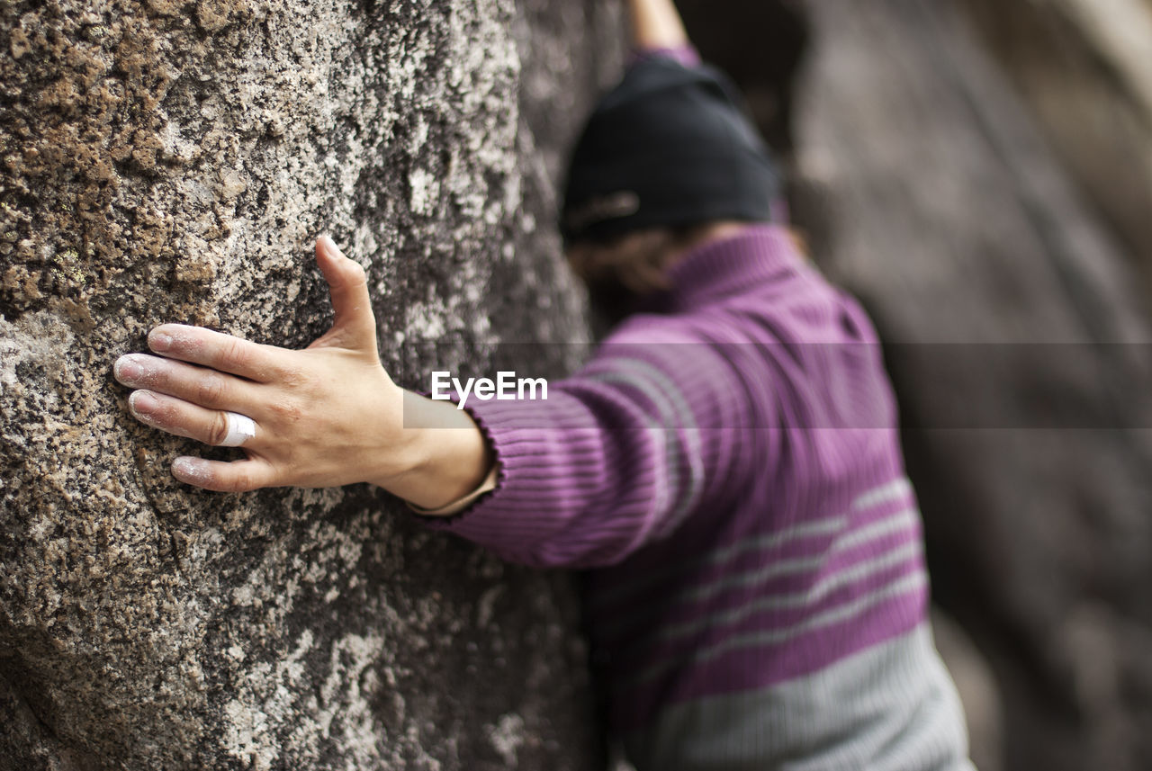 Rear view of person climbing rock