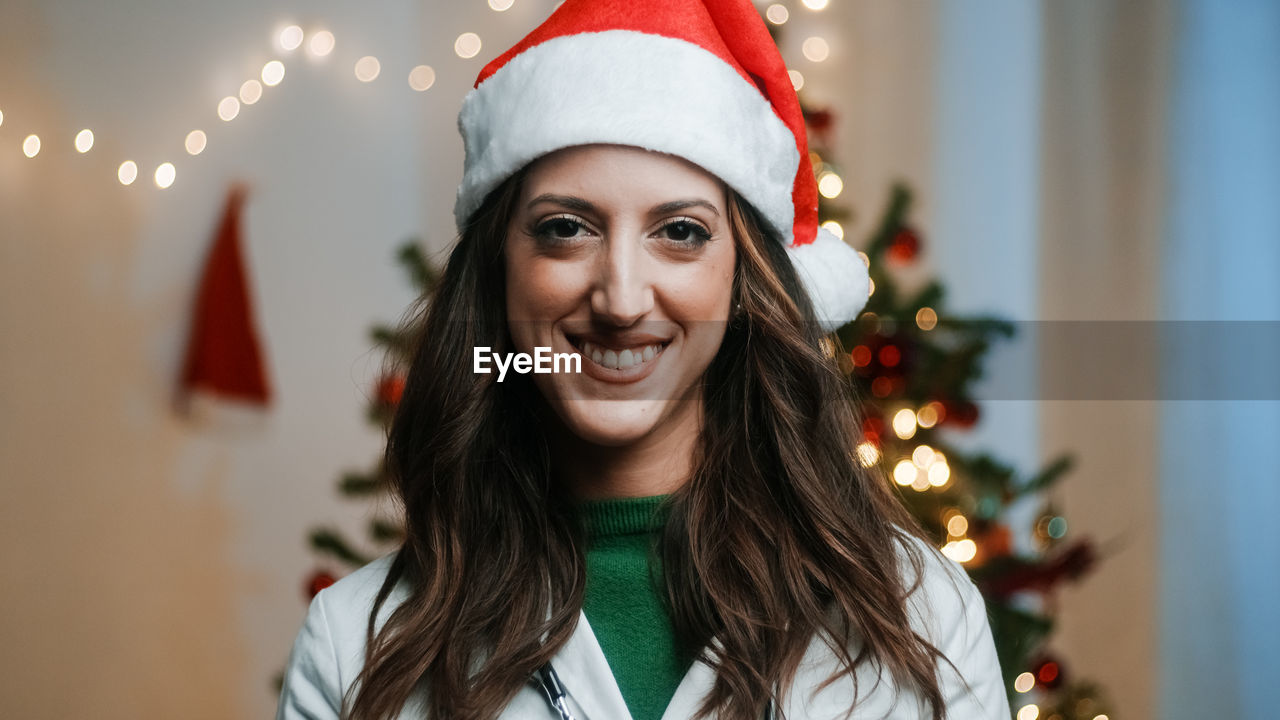 Female doctor smiles with christmas hat