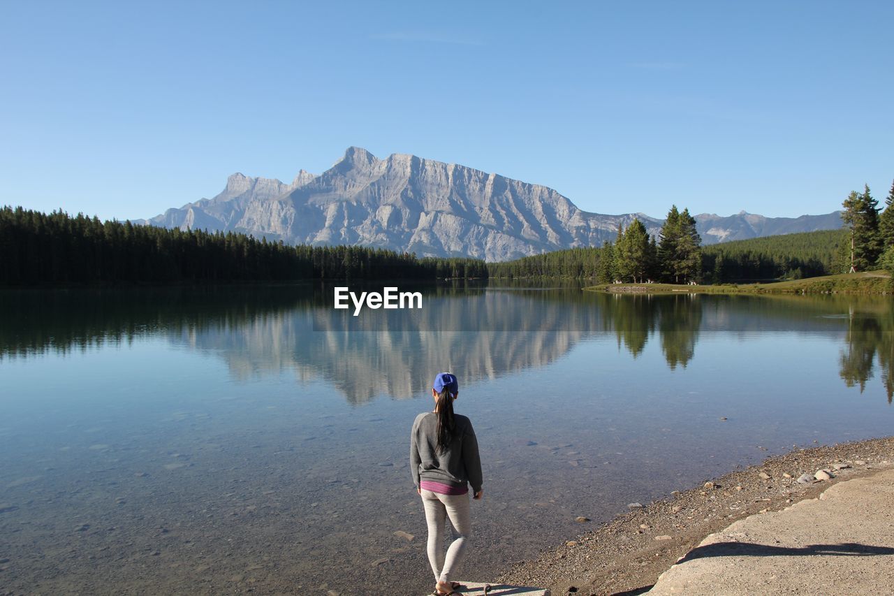 High angle view of woman standing by calm lake