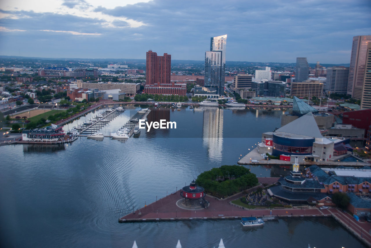 High angle view of buildings by river against sky