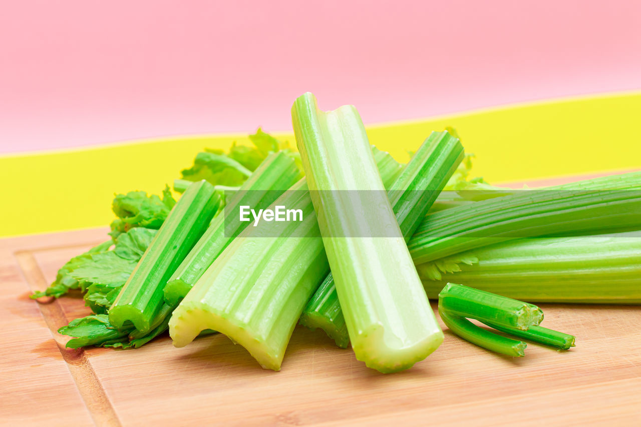 food and drink, food, vegetable, healthy eating, green, wellbeing, produce, freshness, leek, celery, no people, raw food, studio shot, indoors, organic, wood, cutting board, yellow, colored background, asparagus