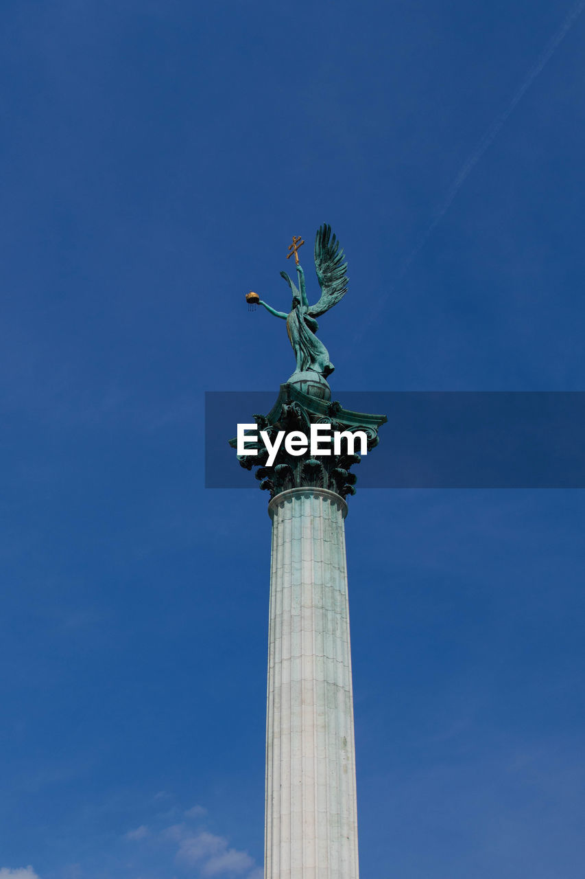 LOW ANGLE VIEW OF STATUES AGAINST BLUE SKY