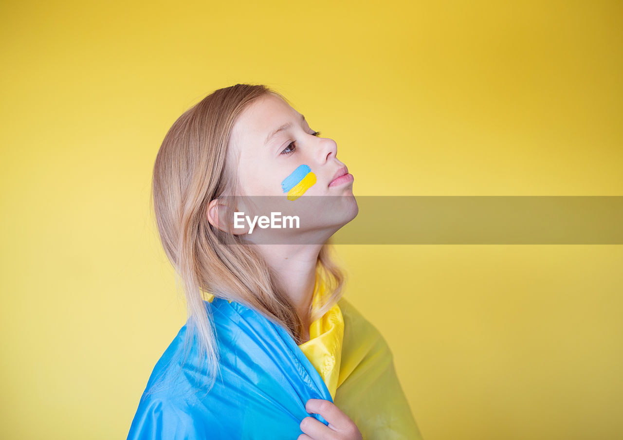 Portrait of young woman with ukrainian flag 