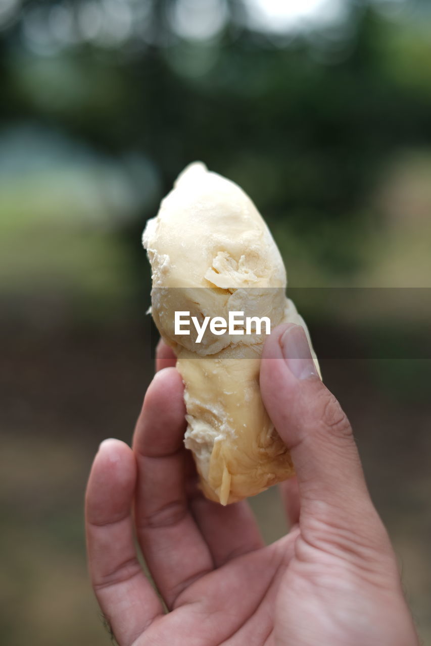 CLOSE-UP OF PERSON HOLDING ICE CREAM