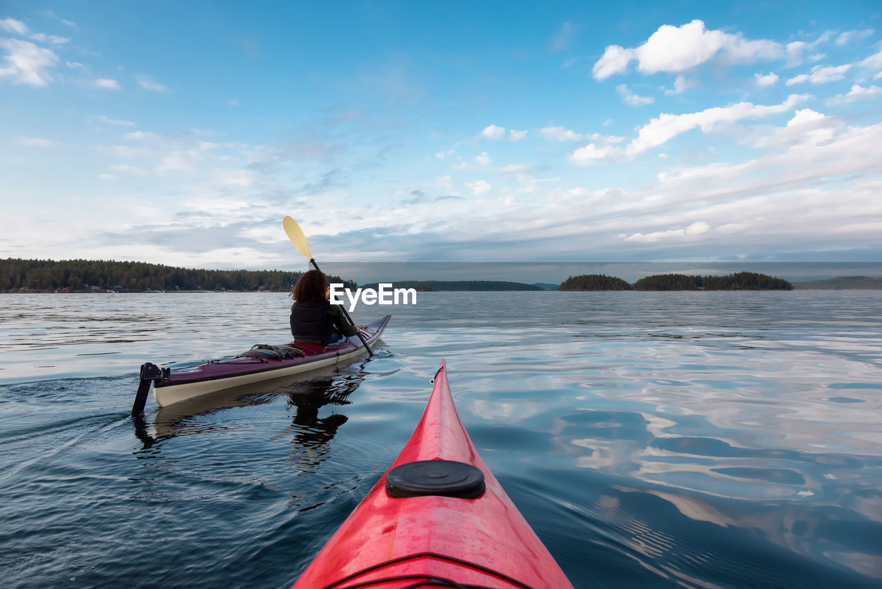 MAN ON BOAT AGAINST SKY