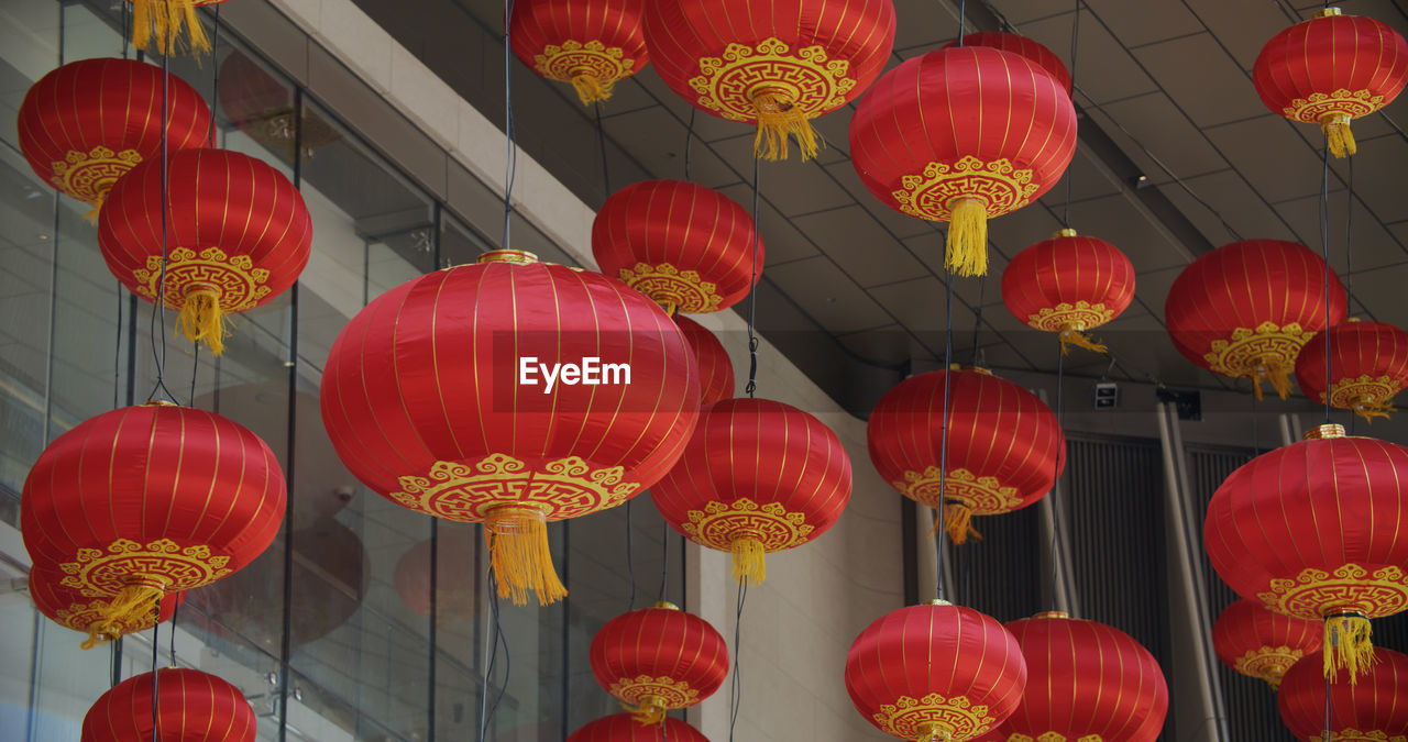 LOW ANGLE VIEW OF MULTI COLORED LANTERNS HANGING IN TRADITIONAL