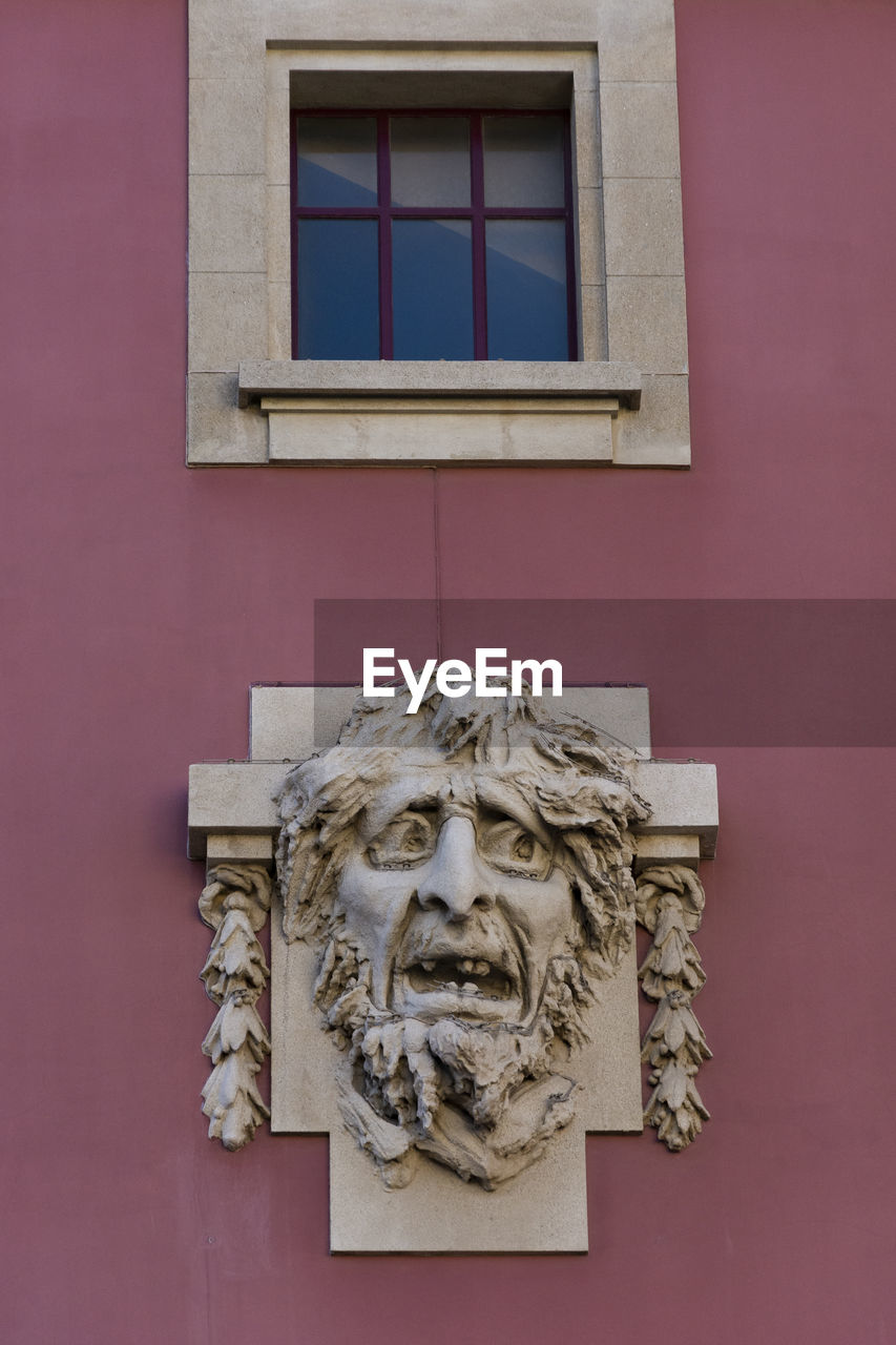 LOW ANGLE VIEW OF STATUE ON BUILDING WALL