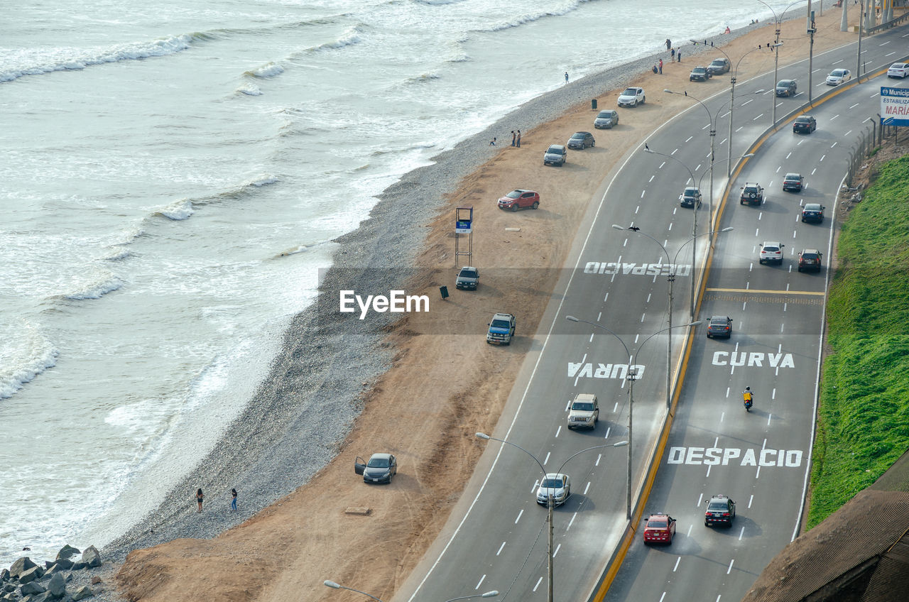 High angle view of cars on road by sea